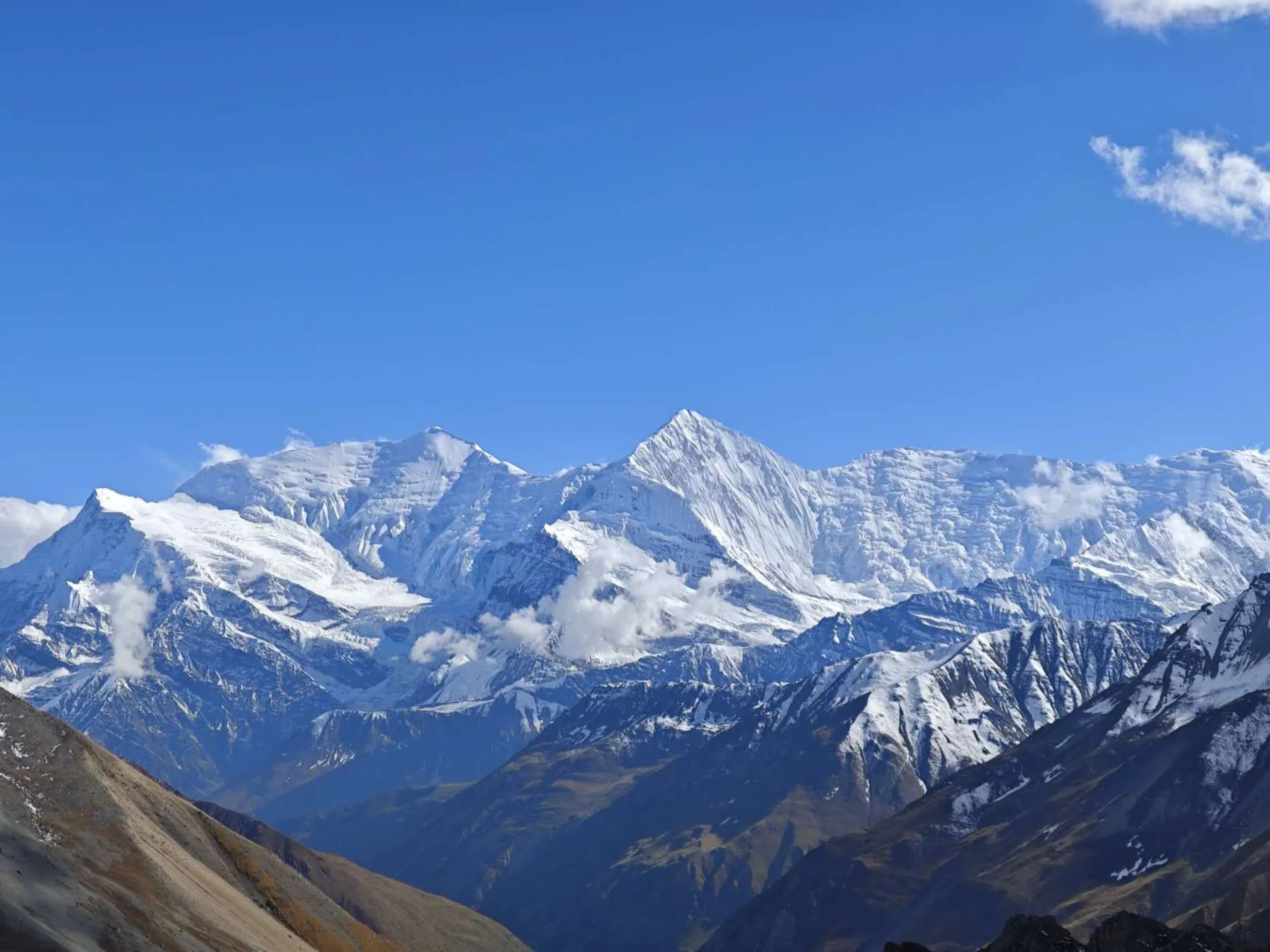 A group of hikers standing atop a scenic mountain ridge, overlooking valleys and peaks during sunrise, representing Mount Horizon Treks & Tours’ adventure experiences.